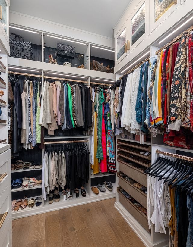 Walk in closet design ideas built out with open shelving, shoe racks, LED lighting and plenty of hanging racks created by California Closets