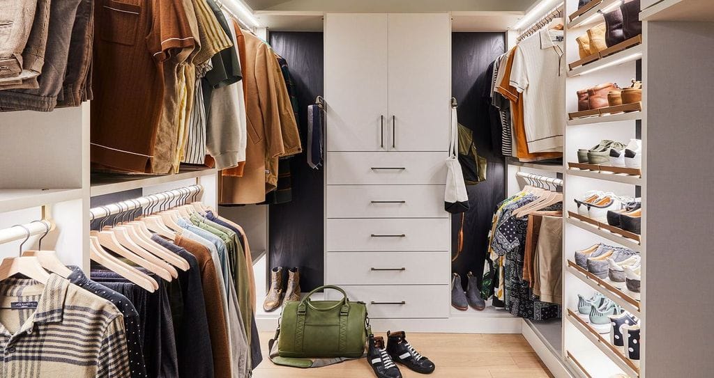 Netflix host Bobby Berk’s walk in cloffice with floor to ceiling custom cabinets for to hide office items created by California Closets