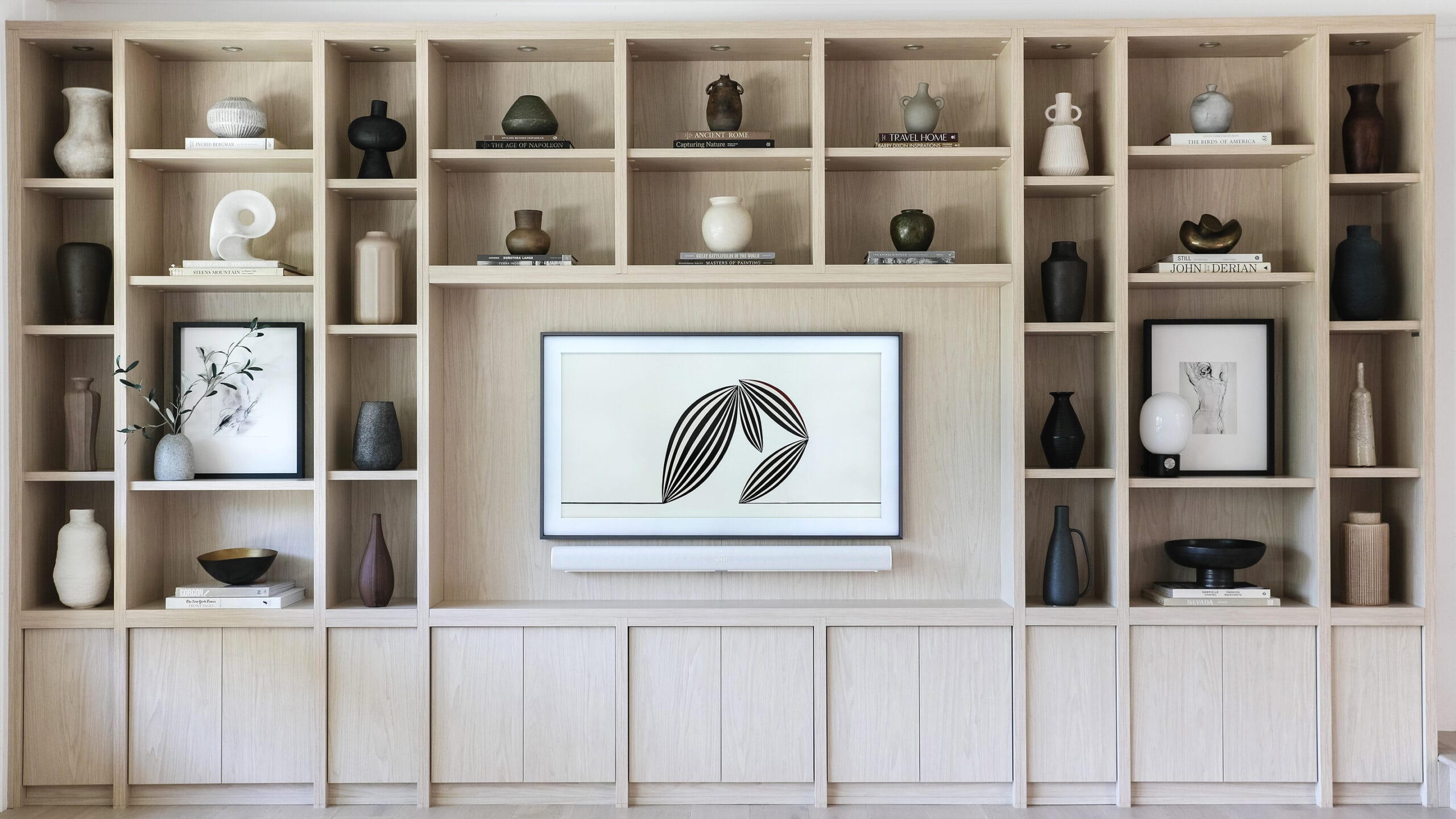 Wall storage shelving cabinets for Entertainment Center designed in light wood finish by California Closets