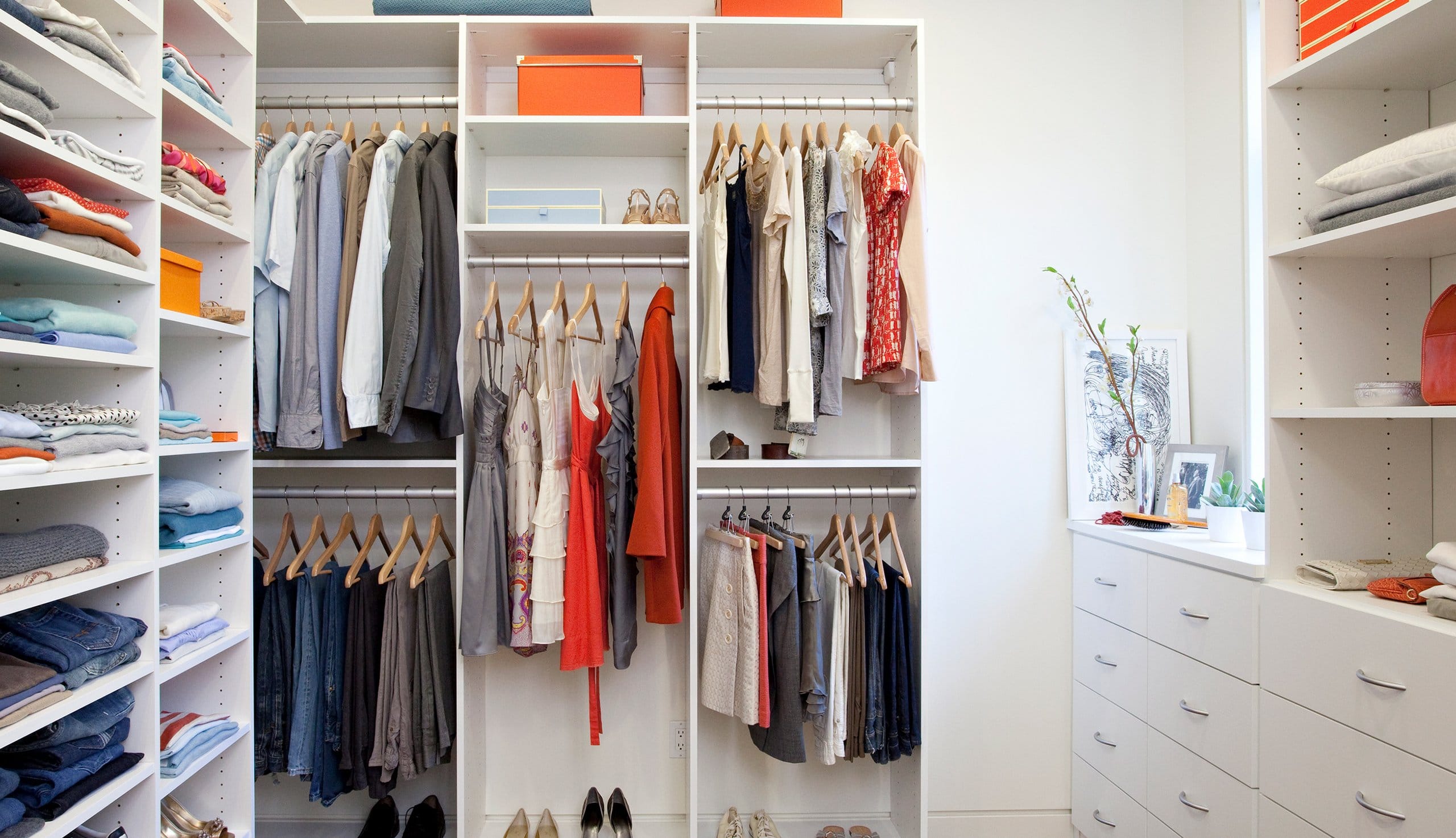 Simple closet system design with bright white finished shoe racks, drawers, poles, cabents created by California Closets
